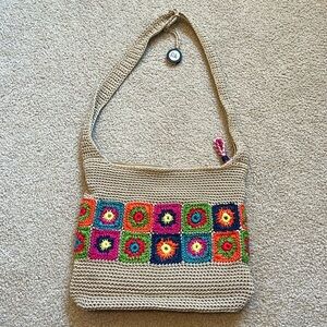 Tan crochet shoulder bag with colorful floral granny square accents by The Sak